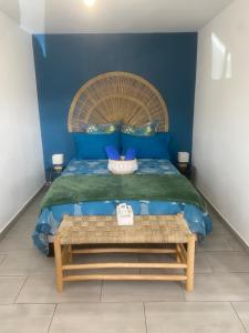 a bedroom with a bed with a blue wall at Villa MYA Location in Saint-Pierre