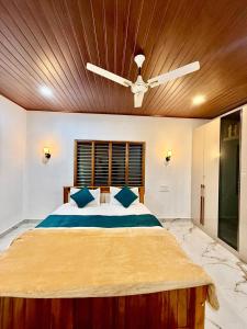 a bedroom with a large bed with a wooden ceiling at Ira Homestay in Sringeri