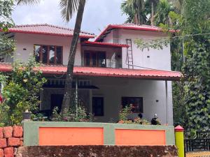 a house with two people sitting in front of it at Ira Homestay in Sringeri