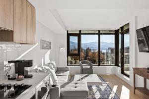 a kitchen and living room with a view of the mountains at Beach Lake Resort in Kelowna