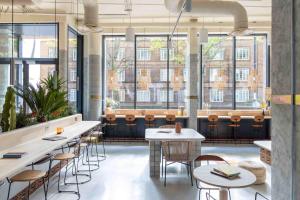 a restaurant with tables and chairs and large windows at Bermonds Locke, Tower Bridge in London