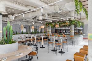 a restaurant with tables and chairs and plants at Bermonds Locke, Tower Bridge in London