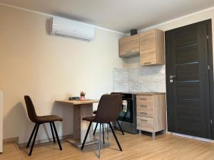 a kitchen with two chairs and a table and a counter at Kálvária panzió in Tata