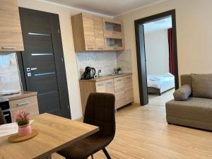 a kitchen and living room with a table and a couch at Kálvária panzió in Tata