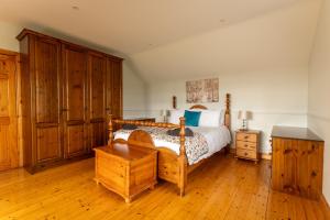 a bedroom with a bed with wooden furniture and wooden floors at Stone House , Boyne Valley Views in Donore