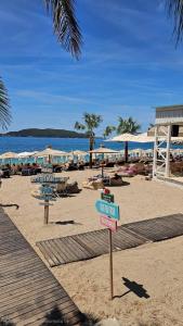 a beach with many umbrellas and chairs on the sand at rašo in Pržno