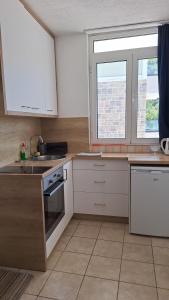 a kitchen with white cabinets and a sink and a window at rašo in Pržno +6 photos