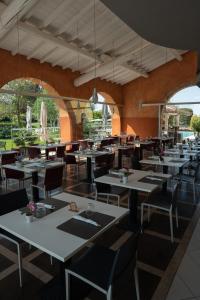 a restaurant with white tables and chairs and windows at Hotel Corte Del Paggio in Valeggio sul Mincio