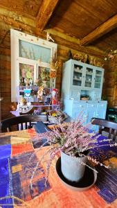 a dining room with a table with purple flowers on it at Cicha Chata in Wójtowa