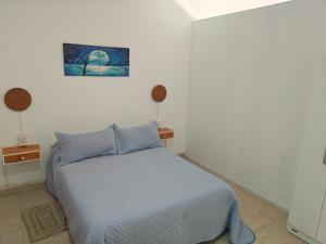 a bedroom with a bed with a blue comforter at La Esquina de Norma in General Villegas