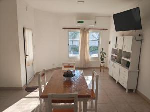 a dining room with a table and chairs and a television at La Esquina de Norma in General Villegas