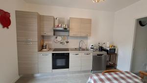a kitchen with wooden cabinets and a sink and a stove at Casa Lilli in Zogno