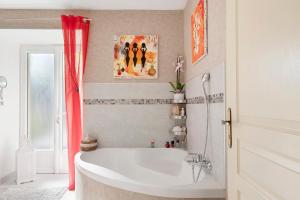 a bathroom with a white tub and a red curtain at Lacelledort in La Celle-Saint-Avant +32 photos