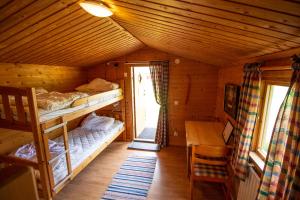 a room with bunk beds and a desk in a cabin at Gopshusgården - Rum & Stugor in Mora