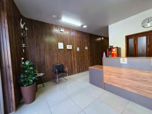 a lobby with a reception desk and a potted plant at Hotel Três Passos - Prox ao Aeroporto e Rodoviária in Porto Alegre