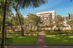 um parque com um banco em frente a um edifício em Presidente Hotel em Poços de Caldas