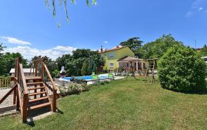 a yard with a playground and a house at House Roza 2065 in Žminj