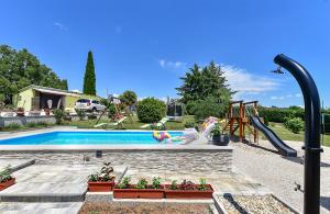 a swimming pool with a slide and a playground at House Roza 2065 in Žminj