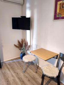 a dining room with a table and a tv on the wall at Apartment Luka in Tučepi