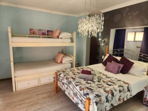 a bedroom with two bunk beds and a chandelier at Villa Mexicana Guesthouse in Kimberley