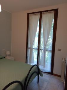 ein Schlafzimmer mit einem Bett und einem großen Fenster in der Unterkunft MAISON MARGÙ in  Monvalle  + 25 Fotos