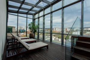 ein Wohnzimmer mit Balkon und vielen Fenstern in der Unterkunft Graffit Gallery Design Hotel in Warna
