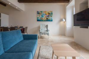 a living room with a blue couch and a table at Valletta Suite Drew in Valletta