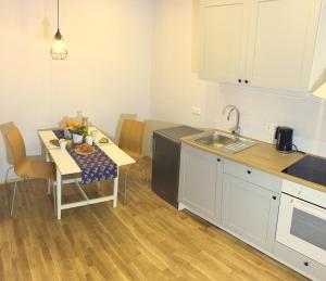 a kitchen with a table and a sink and a table and chairs at Suur-Ameerika Apartment in Tallinn