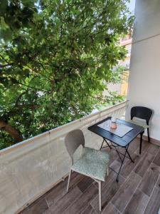 a table and chairs on a balcony with a tree at Apartment Luka in Tučepi