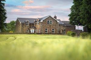 a large brick house on a grassy field at Stone House , Boyne Valley Views in Donore