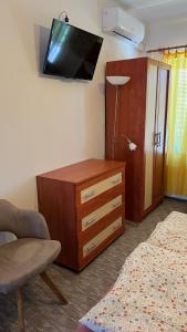 a living room with a dresser and a tv on the wall at Adria penzión in Štúrovo
