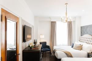 a hotel room with a bed and a desk with a chair at Rodd Charlottetown in Charlottetown