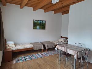 a room with two beds and a table and chairs at Pensiunea Rose in Păuleni-Ciuc