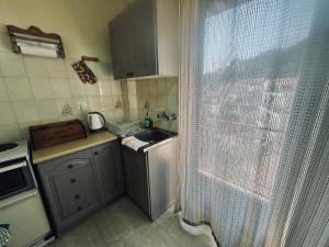 a small kitchen with a sink and a window at Stay for 2 by Alecos Studios in Poros