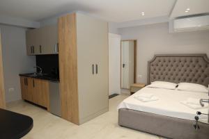 a bedroom with a large bed and a kitchen at Vila Gabriel in Shkodër