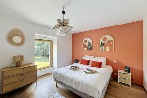 a bedroom with a large bed and a window at Maisons de Familles Quiet family-friendly vacation rental with a spa in Équilly