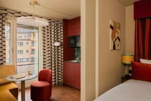 a room with a bed and a table and a kitchen at Locke am Platz Zurich in Zurich
