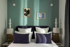 a bedroom with a bed with purple and white pillows at Hôtel Marais Hôme in Paris