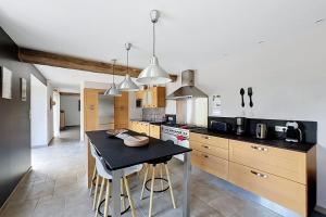 a kitchen with a table and chairs in it at Maisons de Familles Quiet family-friendly vacation rental with a spa in Équilly +20 photos