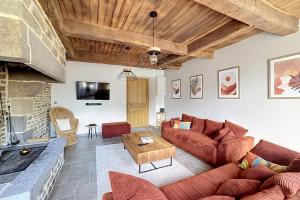 a living room with a couch and a table at Maisons de Familles Quiet family-friendly vacation rental with a spa in Équilly