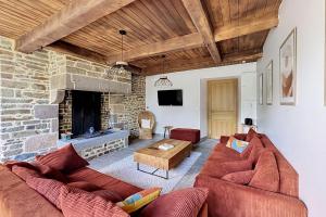 a living room with two couches and a stone fireplace at Maisons de Familles Quiet family-friendly vacation rental with a spa in Équilly
