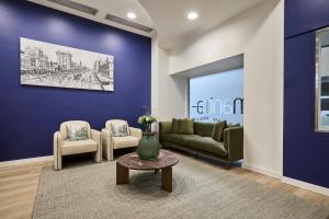 a living room with a couch and two chairs and a table at Mantra Adelaide Central in Adelaide