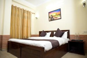 a bedroom with a large bed in a room at Hotel King By Panch Aarohan in Pithorāgarh +4 photos