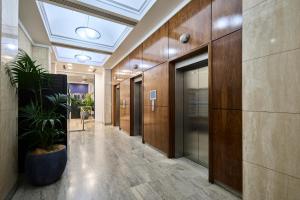 a hallway of an office building with a potted plant at Mantra Adelaide Central in Adelaide