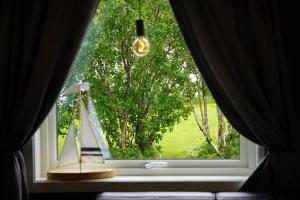 a window with a view of a tree at Panorama Valley Lofoten in Bøstad +49 photos