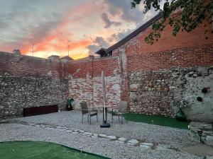 a table and chairs in front of a brick wall at Villa Cantalupo 1 in Sillavengo