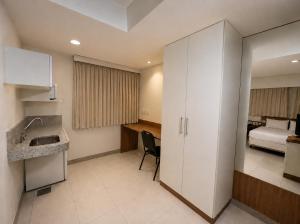 a bathroom with a sink and a room with a bed at Premium Executive Hotel Itabira in Itabira