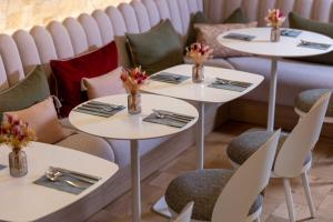 a row of tables in a restaurant with flowers on them at Hôtel Marais Hôme in Paris