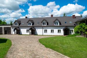 a large white house with a driveway at Agroturystyka Nad Hańcza - apartament in Błaskowizna