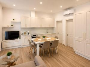 a kitchen and dining room with a table and chairs at Il-Kenn ta Roża Maisonette in Qala